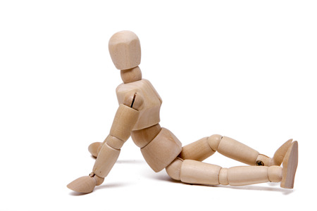 Close up view of a wooden dummy relaxing isolated on a white background.の写真素材