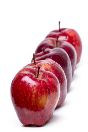 Close up view of some red apples in a row isolated on a white background.の写真素材
