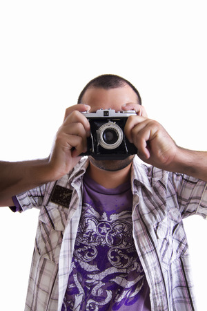 View of a young man with a retro vintage photographic camera isolated on a white background.の写真素材