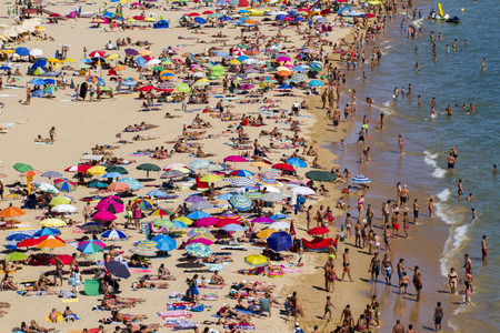 Broad view of a crowded beach on Portimao, Portugal.のeditorial素材
