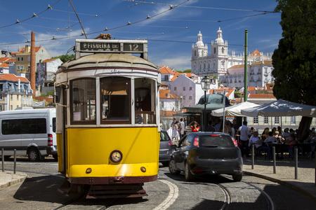 View of the vintage famous yellow electrical trams circulating still today in Lisbon, Portugal.のeditorial素材