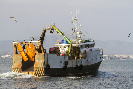 View of a fishing ship exiting through Ria Formosa marshlands, located on Faro, Algarve.