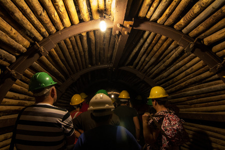 View of a dark eerie mining tunnel with tourists.