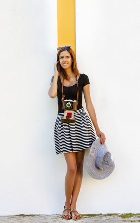 Lifestyle outdoor retro vintage young girl with a photographic camera in the city.の写真素材