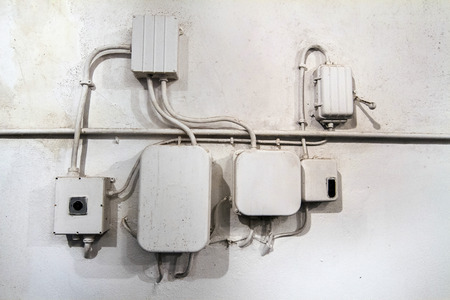 View of an old white electrical network of cables on a wall.