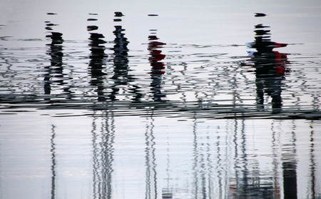 View of reflection of people distorted on the water on the docks.の写真素材