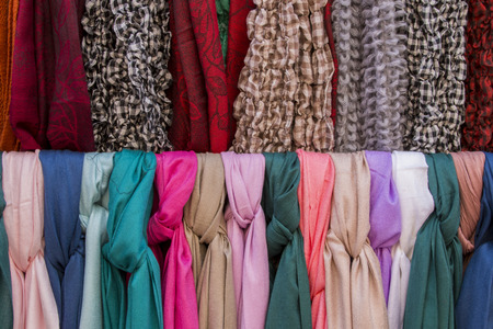 Close up view of many stylish scarfs for sale in a store.