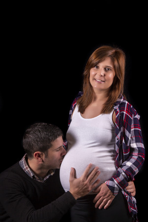 Close view of a expecting pregnant couple against a black background.の写真素材