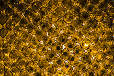 Background wall of bottoms of empty orange glass bottles.の写真素材