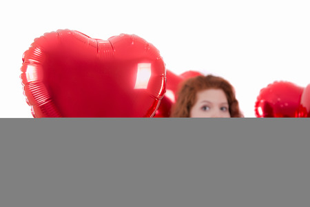 Close up view of a happy young girl between red balloons.の写真素材