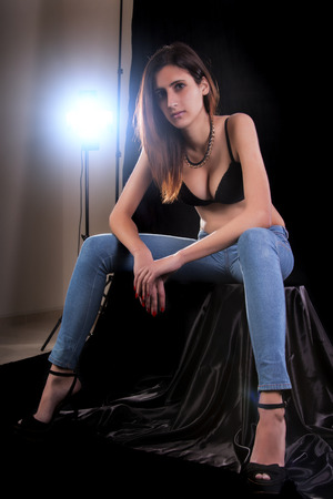 Close up view of a sensual young woman wearing lingerie and jeans.の写真素材