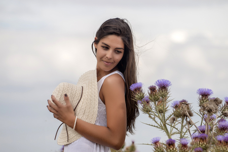 Close view of a beautiful woman on a white dress on the countryside.の写真素材