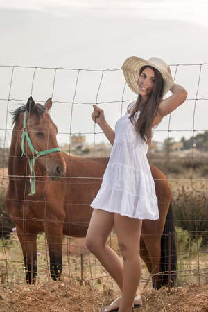Close view of a beautiful woman on a white dress on the countryside.の写真素材