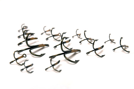 Close up view of treble fish hooks isolated on a white background.