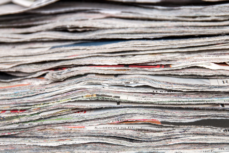 Close view of a slice (cut) pile of used newspapers.