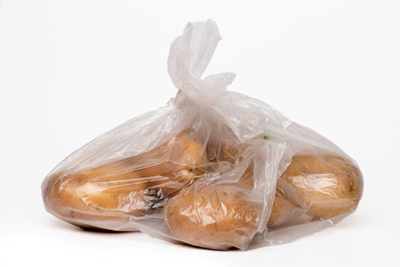 View of some bananas inside a plastic bag isolated on a white background.の写真素材