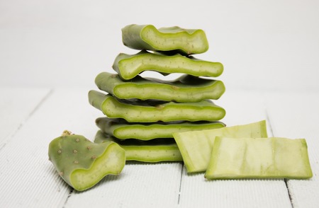 View of a sliced opuntia ficus-indica cactus leaf on a white wooden background.の写真素材