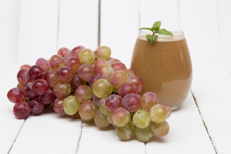 Fresh homemade juice of grapes over a white wooden background.の写真素材