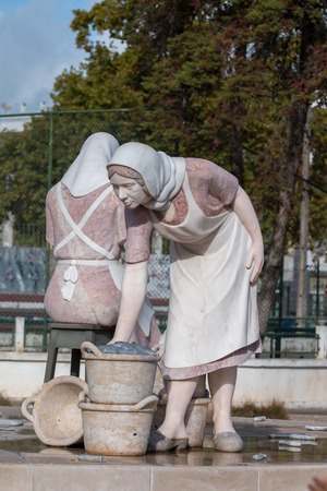 Small statues of working ladies on a roundabout in Portimao city, Portugal.の写真素材