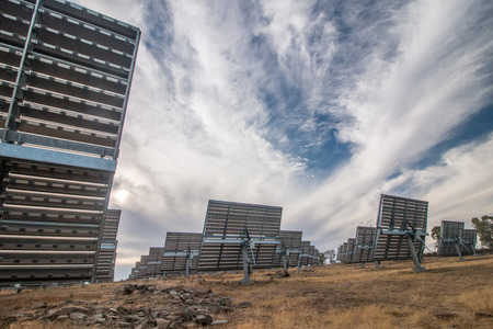 View of a field of photovoltaic solar panels gathering energy on the countryside.