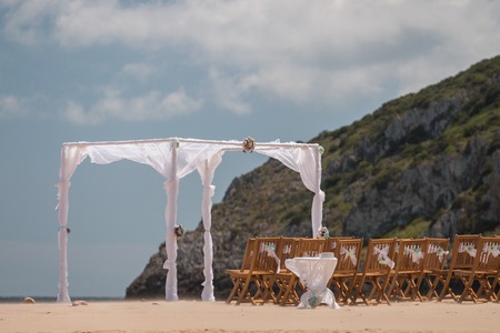View of a simple beach wedding set with chairs and frame.の写真素材