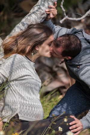 happy pregnant girl and husband in nature relaxing on a tree.の写真素材