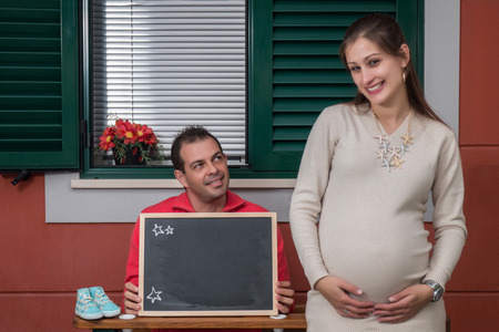 happy pregnant girl and husband sitting expecting their future baby.の写真素材