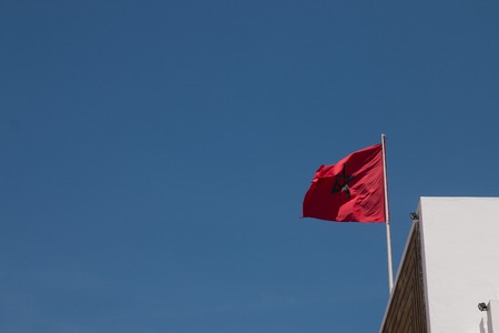 View of a Moroccan flag over a blue sky.の写真素材