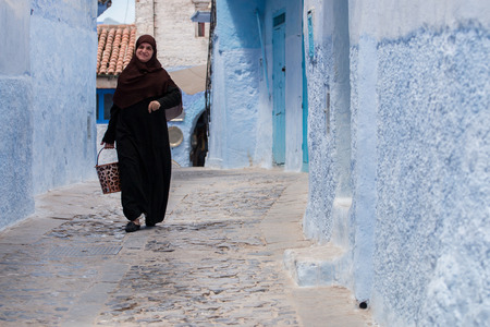 CHEFCHAOUEN, MOROCCO - SEP 11, 2016:  Woman in typical moroccan clothing, walking down the street.のeditorial素材