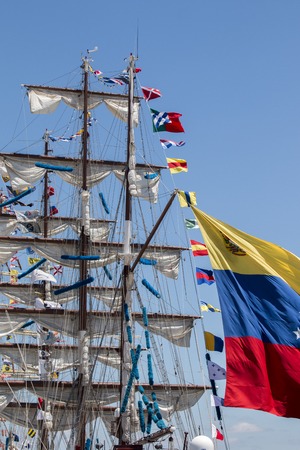 View of majestic Tall Ship with sails with a cloudy sky.