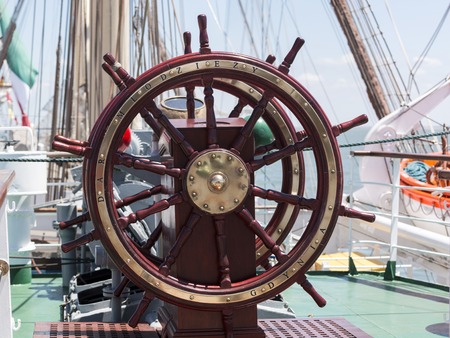 Vintage wooden ship steering wheel on a sail ship.のeditorial素材