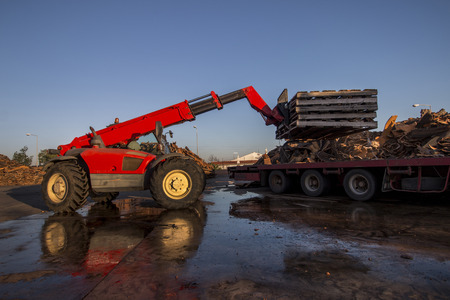 View of a vehicle maneuvering raw cork planks from heavy duty truck.