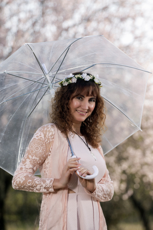View of a beautiful woman with a transparent umbrella on the countryside.の写真素材