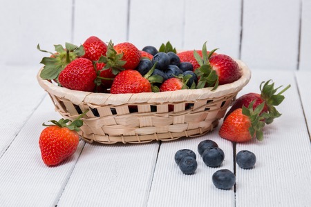 Close view of tasty fruit mix on a white background inside a wicker container.の写真素材
