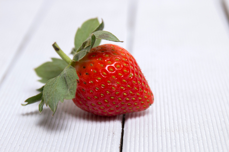 Close view of tasty strawberry  isolated on a white wooden background.の写真素材