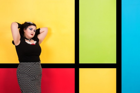 View of pinup vintage girl next to a colorful pop art backdrop.の写真素材