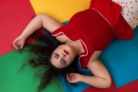 View of pinup vintage girl next to a colorful backdrop.の写真素材