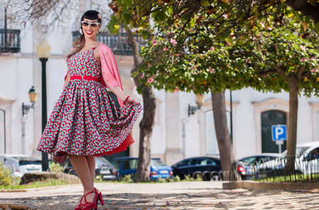 Pinup girl  with dress relaxing in the beautiful urban park.の写真素材