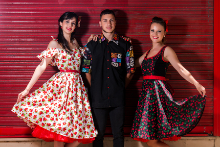 Two woman and a man posing on a vintage style retro clothing.の写真素材