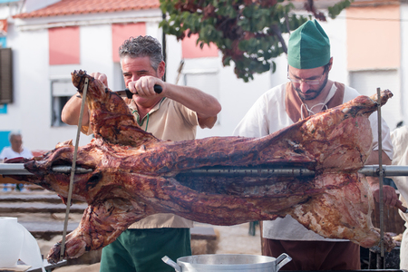 CASTRO MARIM, PORTUGAL - AUGUST 25, 2017: Man roasting a pig in Medieval fair event.のeditorial素材