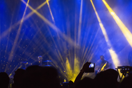 Audience watching a music concert with light rays.のeditorial素材
