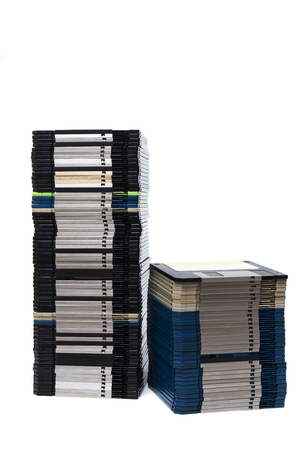 Vertical pile of computer floppy disks isolated on a white background.の写真素材