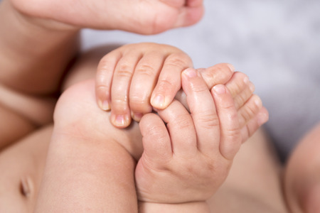 Close up of baby hands and feet of a newborn baby.の写真素材