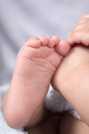 Close up of a cute tiny baby foot of a newborn boy.の写真素材