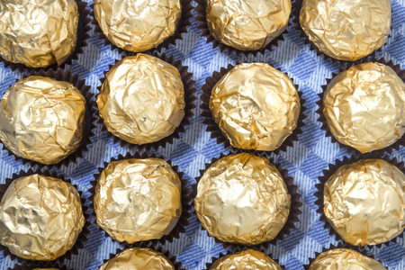 Chocolate candy balls wrapped on beautiful golden paper.の写真素材