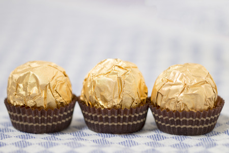 Chocolate candy balls wrapped on beautiful golden paper.の写真素材