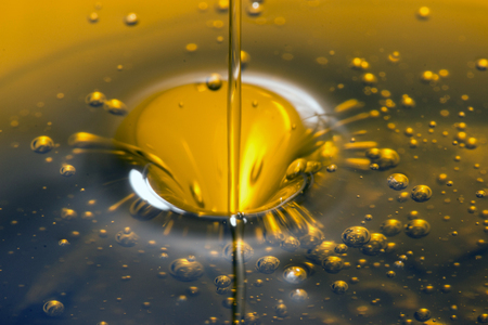 Close up view of pouring olive oil golden liquid.の写真素材