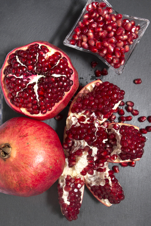 Close up view of tasty pommegranate fruit on top of a slate stone.の写真素材