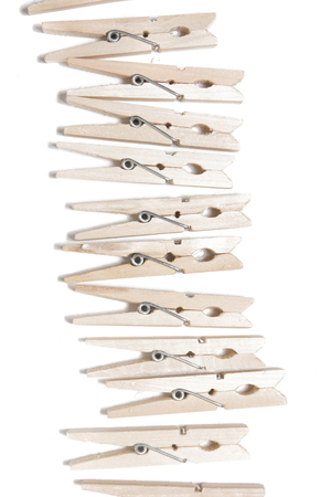 Aligned clothing pegs isolated on a white background.の写真素材