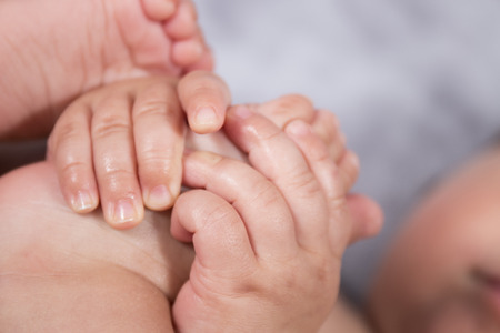Close up of cute and tiny baby feet and hands.の写真素材